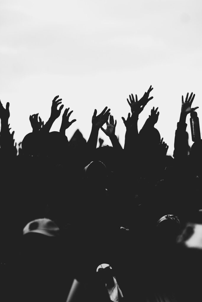 silhouette of people raising their hands
